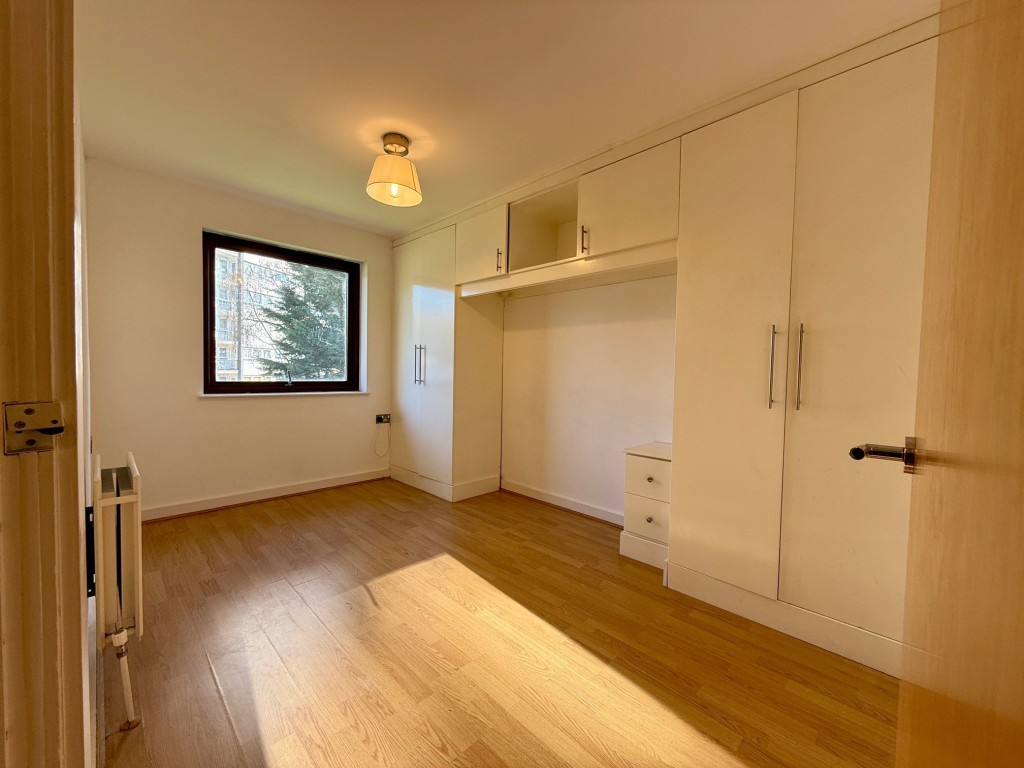 Lot: 105 - SECOND FLOOR FLAT WITH EN-SUITE TO MASTER BEDROOM - Bedroom with fitted furniture and space for bed